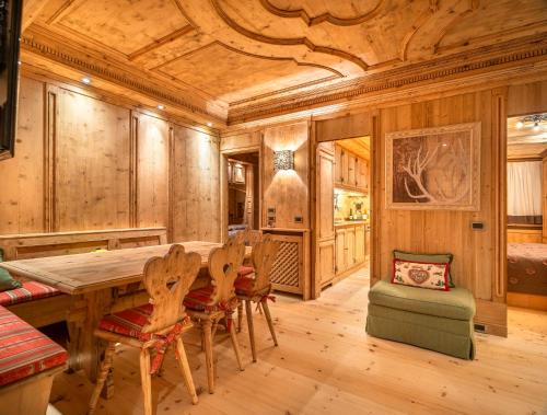 a dining room with a wooden ceiling and a table and chairs at Elegant Tablà with Garden R&R in Cortina dʼAmpezzo