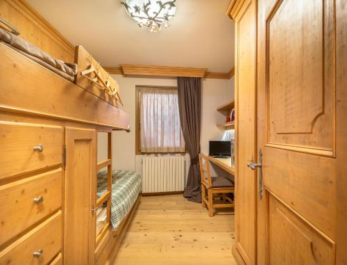a bedroom with a bed and a desk in a room at Elegant Tablà with Garden R&R in Cortina dʼAmpezzo
