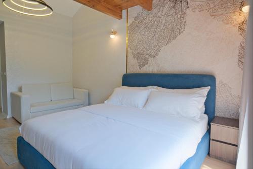 a bed with a blue headboard in a room at Hotel Valbor in Tropojë