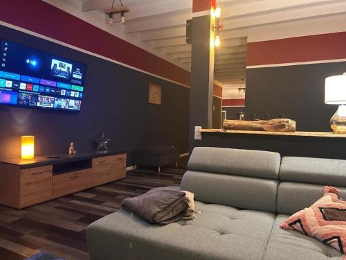 a living room with a couch and a flat screen tv at Rhin Quartier Ferienwohnung Loft-Style in Rheinsberg