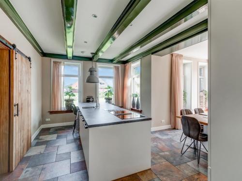 an open kitchen with a counter and a dining room at Stylish Farmhouse with Spa Tub in Kootstertille