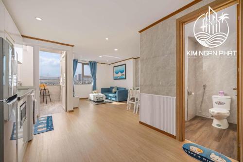 a bathroom with a toilet and a living room at Kim Ngan Phat Deluxe Apartment in Danang