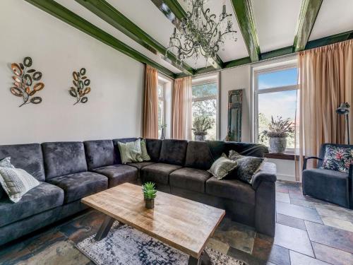 a living room with a couch and a table at Stylish Farmhouse with Spa Tub in Kootstertille