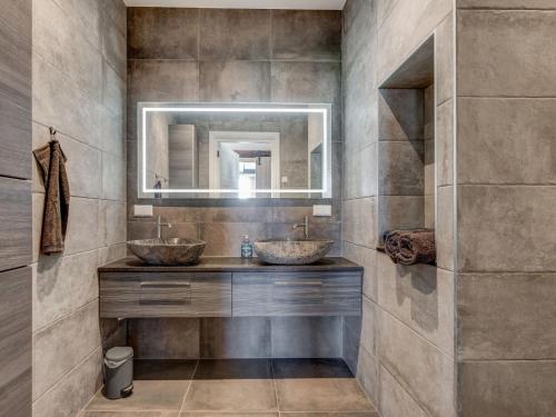 a bathroom with two sinks and a mirror at Stylish Farmhouse with Spa Tub in Kootstertille