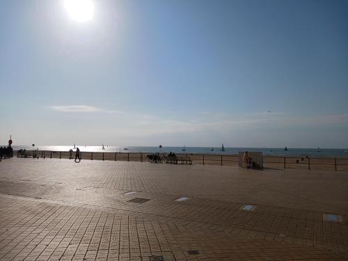 a beach with people walking on the sand and the ocean at Studio Louisa met prachtig zeezicht in Ostend