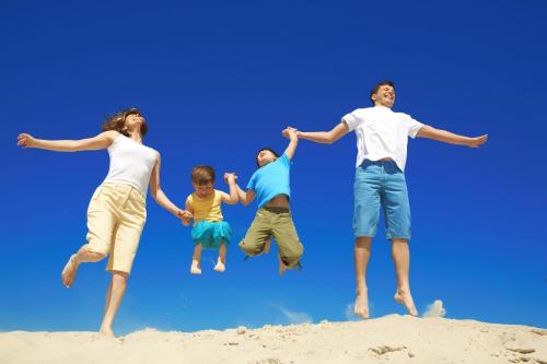 a family jumping in the sand at the beach at Lovely Caravan At Manor Park, Nearby Hunstanton Beach In Norfolk Ref 23029T in Hunstanton