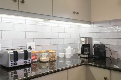 a kitchen counter with a toaster and a coffee maker at High Season Farm Luxury Cottages in Hermanus