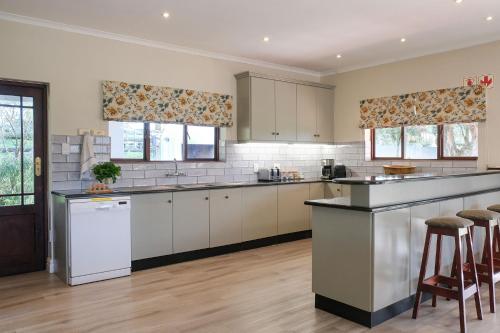 a kitchen with white cabinets and a counter top at High Season Farm Luxury Cottages in Hermanus