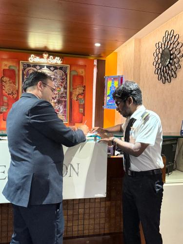 two men are standing at a counter in a restaurant at The Four Seasons Recreation in Jālgaon