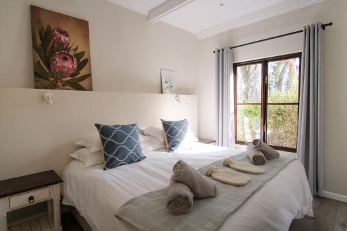 a bedroom with a bed with towels on it at High Season Farm Luxury Cottages in Hermanus