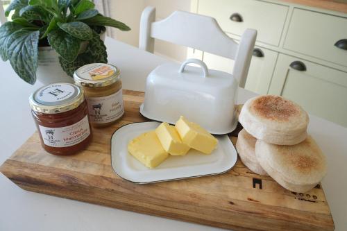 a cutting board with cheese and bread on a counter at High Season Farm Luxury Cottages in Hermanus