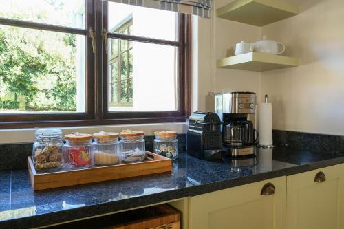 a kitchen with a counter top with jars of food at High Season Farm Luxury Cottages in Hermanus