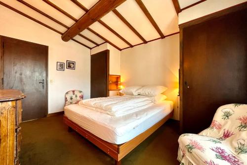 a bedroom with a bed and two chairs in it at L’Héritage Régence in Megève
