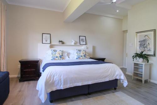 a bedroom with a large bed with blue and white sheets at High Season Farm Luxury Cottages in Hermanus