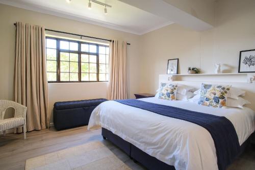 a bedroom with a large bed and a window at High Season Farm Luxury Cottages in Hermanus