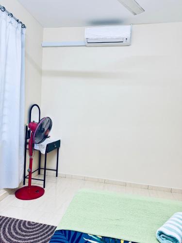 a white room with a fan and a green rug at Rosali Homestay in Melaka