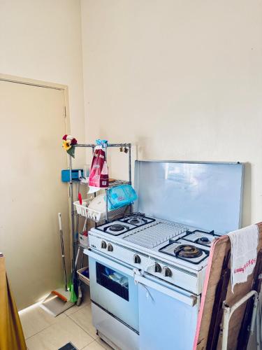 a kitchen with a white stove in a room at Rosali Homestay in Melaka