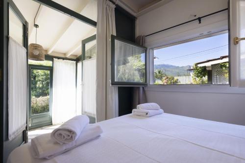 a bedroom with two towels on a bed with a window at Apartamentos del Norte in Andrín
