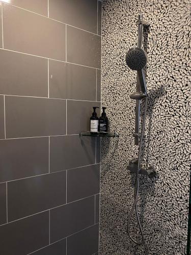 a shower in a bathroom with a tile wall at The Terraza A212 - Cozy apartment in Amphoe Koh Samui