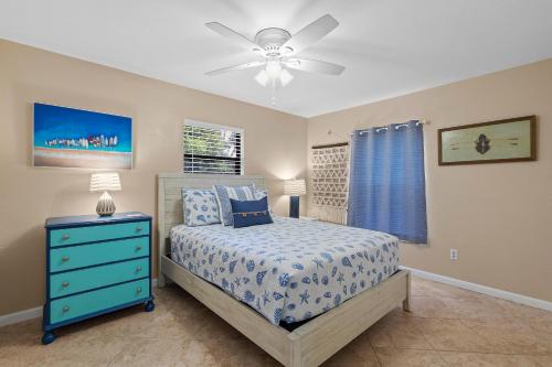 Un dormitorio con una cama y un ventilador de techo. en Pelican's Cove, en Port Orange