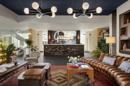 a large living room with a couch and a table at Graduate by Hilton Dallas in Dallas