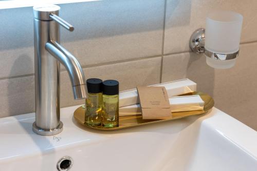 a bathroom sink with a tray with essential oils on it at Ariadne de Potie Maisonette - Chania Old Town in Chania