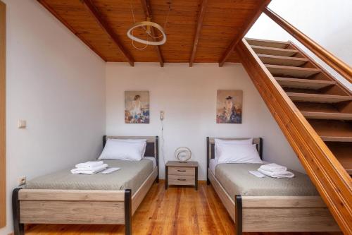 two beds in a room with a staircase at Ariadne de Potie Maisonette - Chania Old Town in Chania