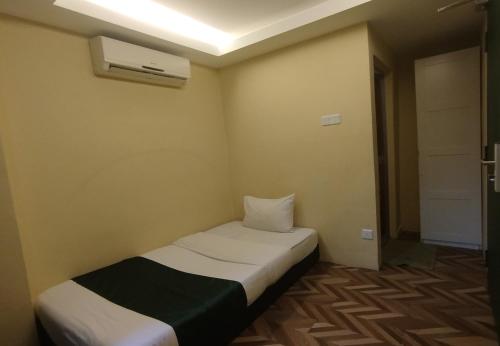 a small room with a bed and a air conditioner at Fast Hotel Setapak Near Tunku Abdul Rahman UMT KL in Kuala Lumpur