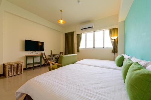 a hotel room with two beds and a television at Travel J in Taitung City
