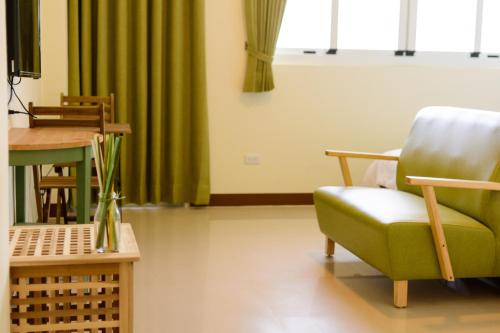 a waiting room with a green chair and a table at Travel J in Taitung City