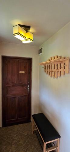 a room with a door and a bench and a light at Nad Strumieniem in Cisna