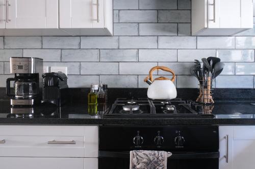 a kitchen counter with a stove with a tea kettle at High Season Farm Luxury Cottages in Hermanus
