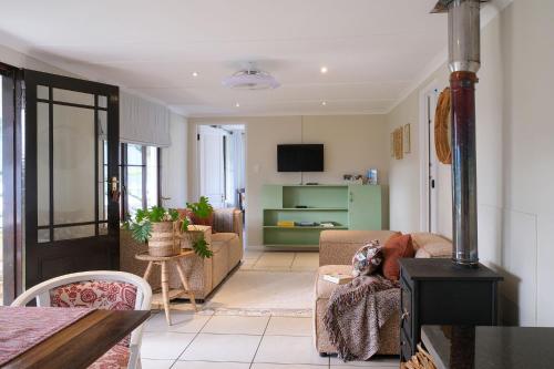 a living room with a couch and a table at High Season Farm Luxury Cottages in Hermanus