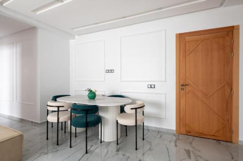 a white dining room with a white table and chairs at TT Holidays Centro in Rabat