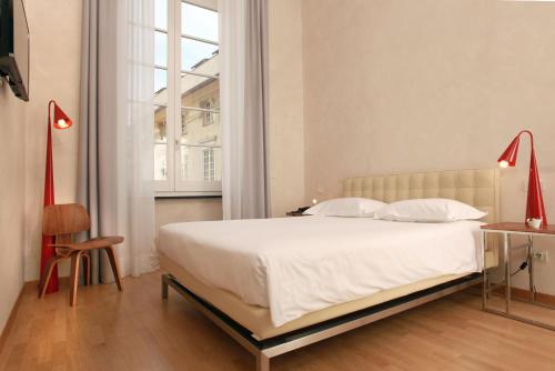 a bedroom with a bed and a desk and a window at Hotel Le Nuvole Residenza d'Epoca in Genoa