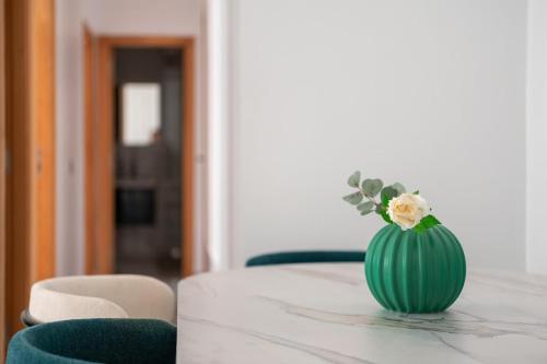 a green vase with flowers sitting on a table at TT Holidays Centro in Rabat