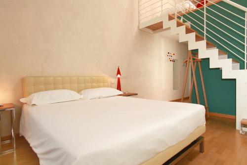 a bedroom with a white bed and a staircase at Hotel Le Nuvole Residenza d'Epoca in Genoa