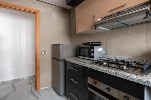 a kitchen with a stove and a microwave at TT Holidays Centro in Rabat