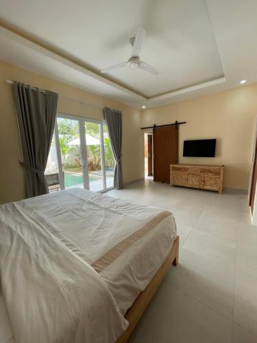 a bedroom with a large bed and a flat screen tv at Luxury 3 Bed Villa in Kuta with Pool in Kuta Lombok