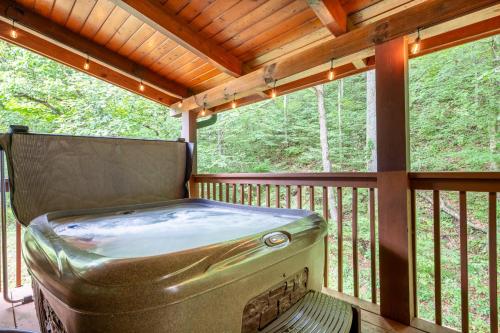 an outdoor hot tub on a screened in porch at Moonshine Hollow By Avada Properties in Boyds Creek