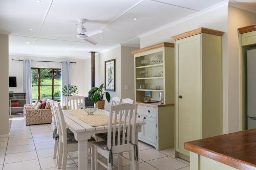a kitchen and dining room with a table and chairs at High Season Farm Luxury Cottages in Hermanus