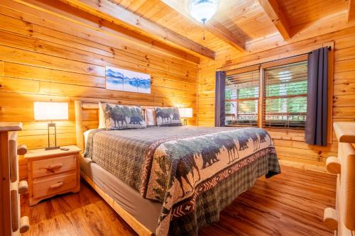 a bedroom with a bed in a log cabin at Moonshine Hollow By Avada Properties in Boyds Creek