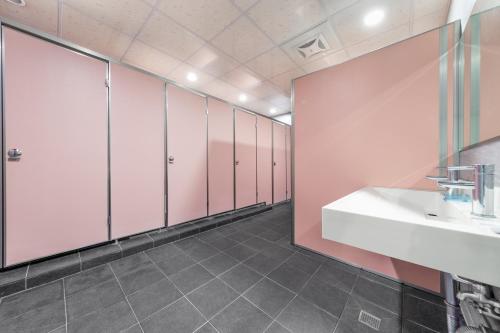 a bathroom with pink cabinets and a white sink at Sun Moon Lake Jinlongshan BnB in Yuchi