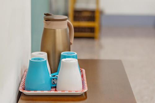 a tray with a coffee pot and cups on a table at Sun Moon Lake Jinlongshan BnB in Yuchi