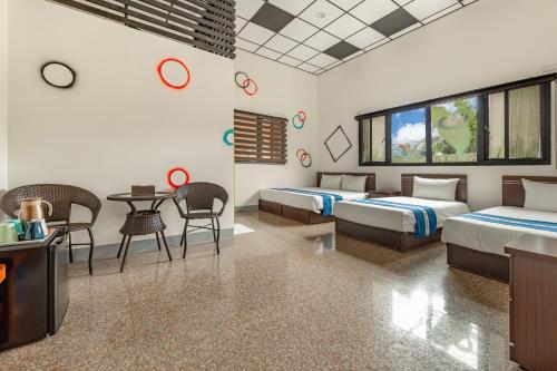 a bedroom with two beds and a table and chairs at Sun Moon Lake Jinlongshan BnB in Yuchi
