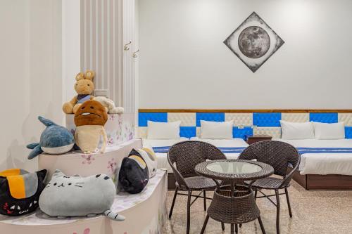 a room with two beds and a table and chairs at Sun Moon Lake Jinlongshan BnB in Yuchi