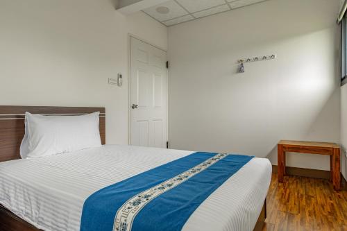 a bedroom with a bed with a blue and white blanket at Sun Moon Lake Jinlongshan BnB in Yuchi