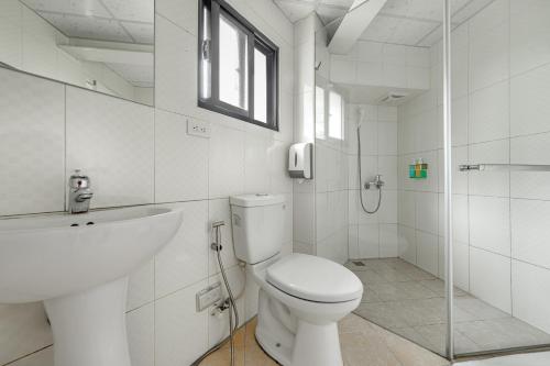 a white bathroom with a toilet and a sink at Sun Moon Lake Jinlongshan BnB in Yuchi