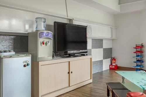 a living room with a tv and a refrigerator at Sun Moon Lake Jinlongshan BnB in Yuchi
