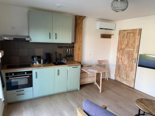 a kitchen with blue cabinets and a table in a room at 't Veurhuus in Ansen